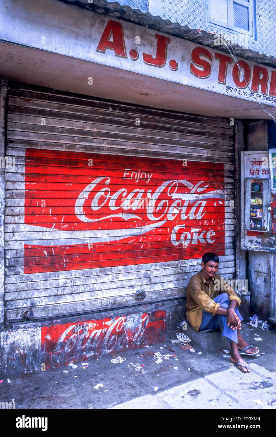 A man passing the day on the step of a shop in Tamil Nadu Stock Photo