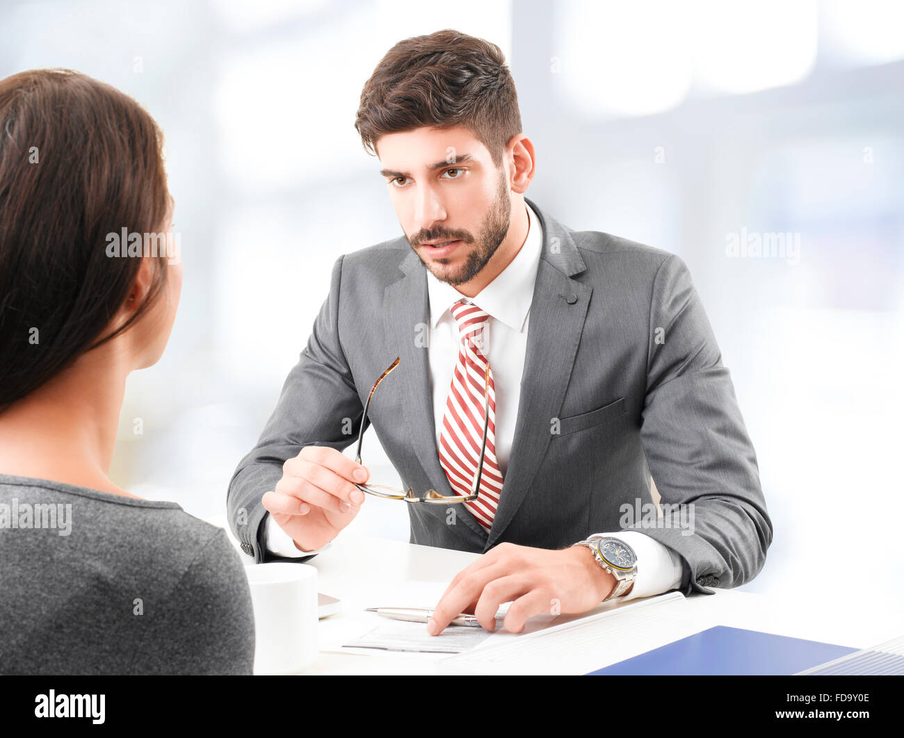 Portrait of confident investment adviser giving advise for busy business woman, while sitting at office. Stock Photo