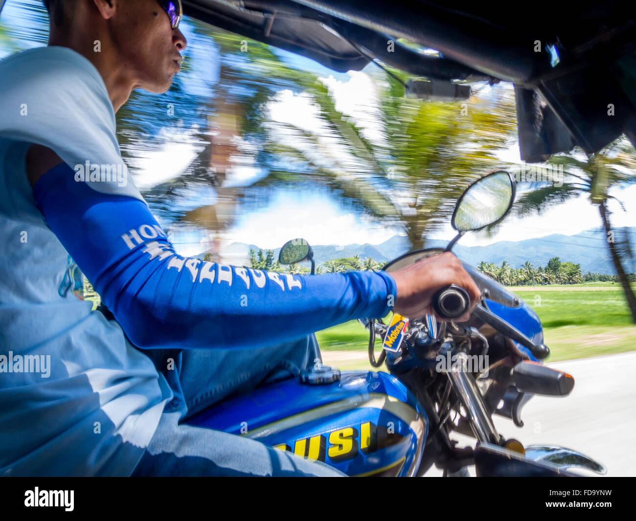 Tricycle driver speeding along in the Philippines Stock Photo