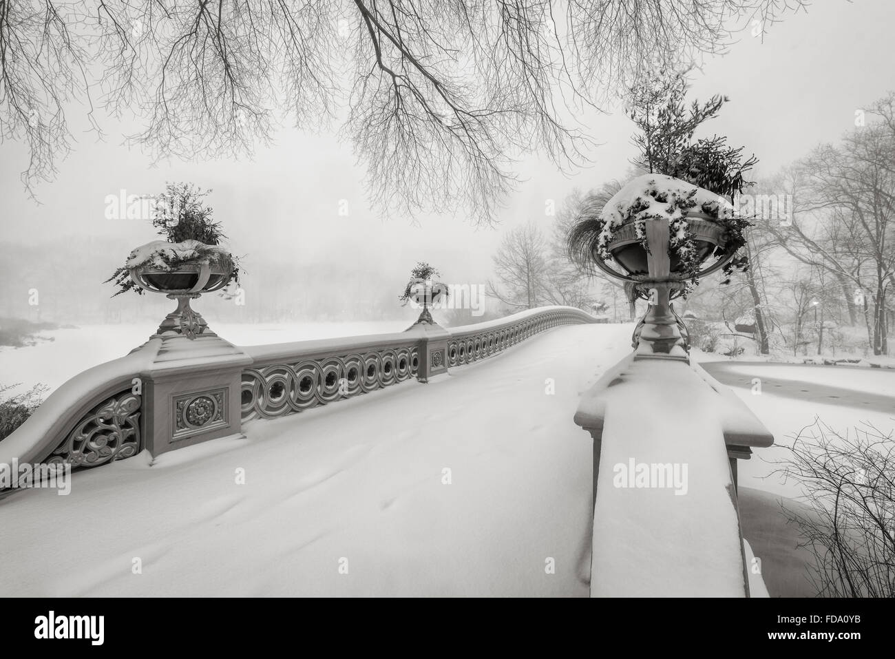 Black & White view of the Bow Bridge in Central Park covered in snow during the blizzard of January 2016. Manhattan, New York Stock Photo