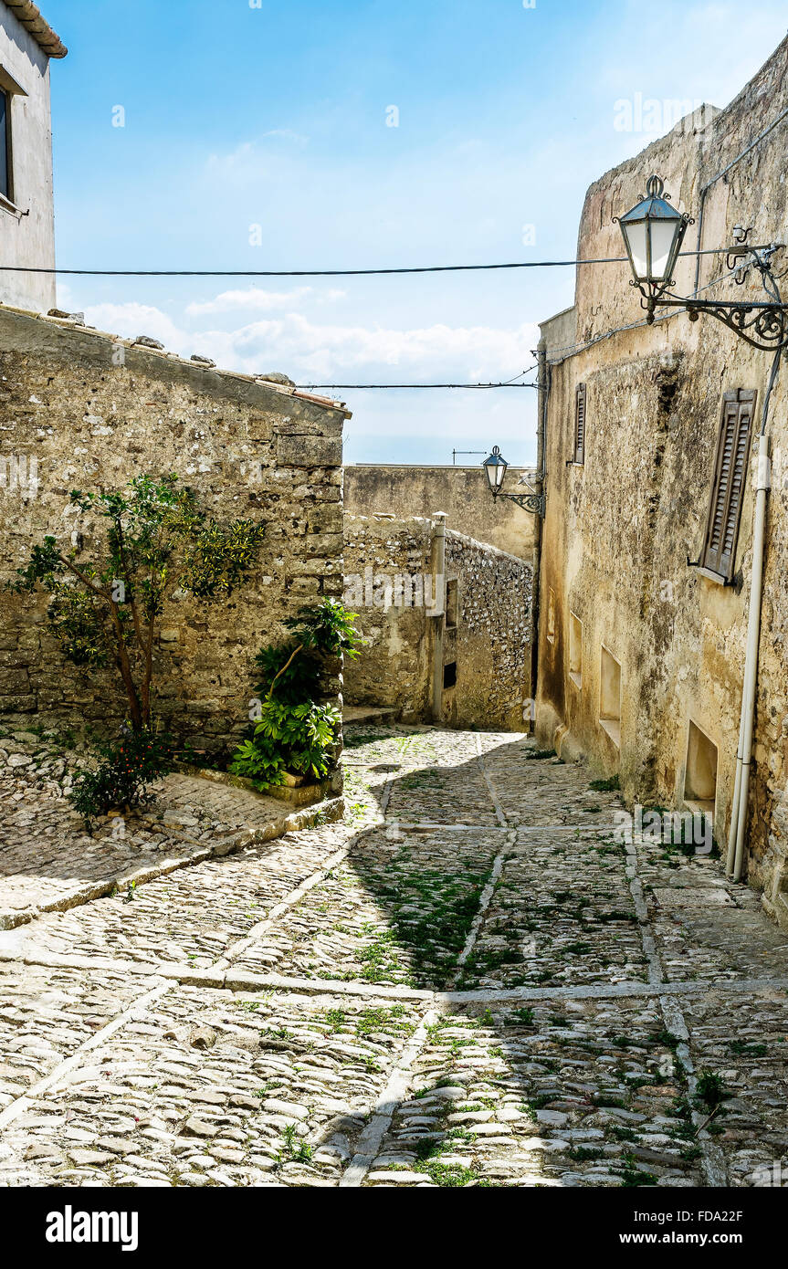 Cobbled street and building exteriors on hillside in historic in Erice, town and comune in the province of Trapani, Sicily, Stock Photo
