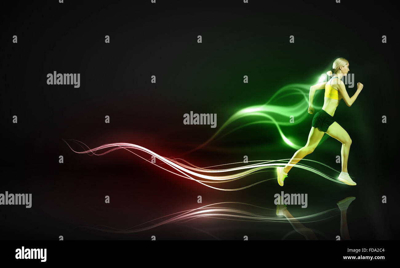 Young woman athlete running fast on dark background Stock Photo - Alamy