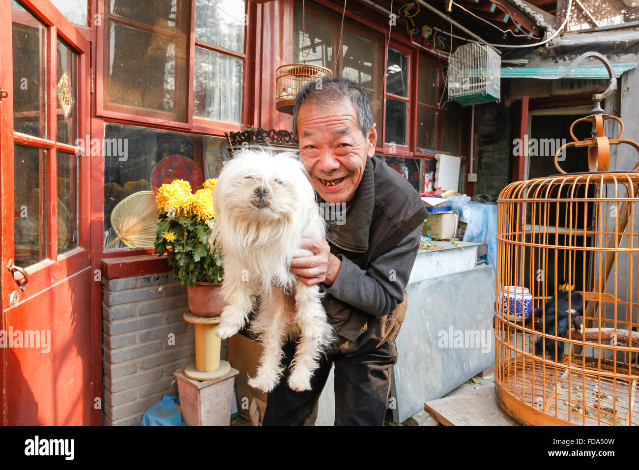 Chinese man and his dog at an outdoor market in central Beijing, China