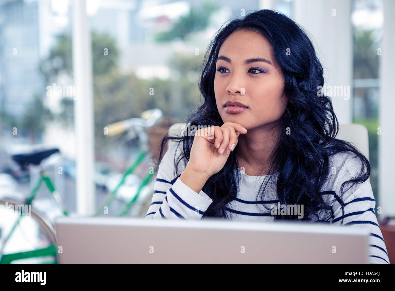 Thoughtful Asian woman with finger on chin Stock Photo - Alamy