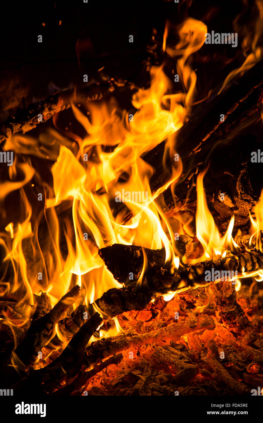 Closeup view of the flames of a wood fire burning branches and logs ...