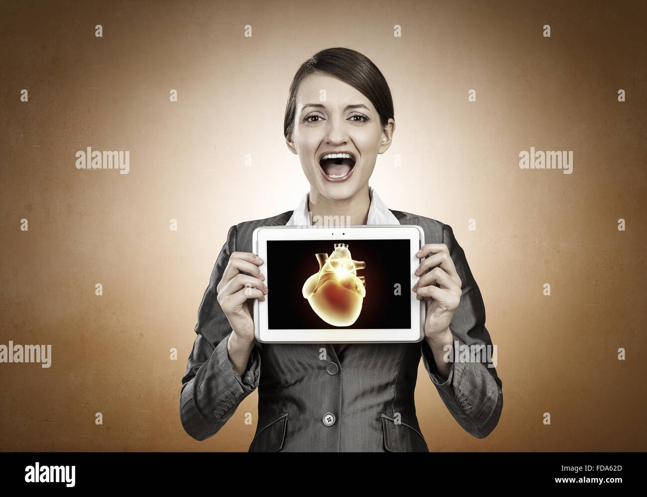 Young businesswoman showing tablet pc against heart Stock Photo