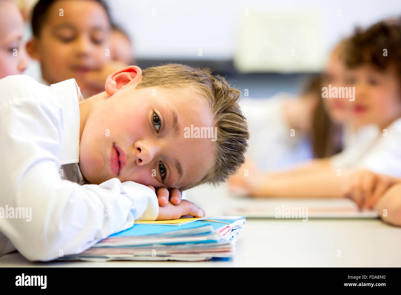 A close up shot of a little boy at school who looks distant and upset. Stock Photo