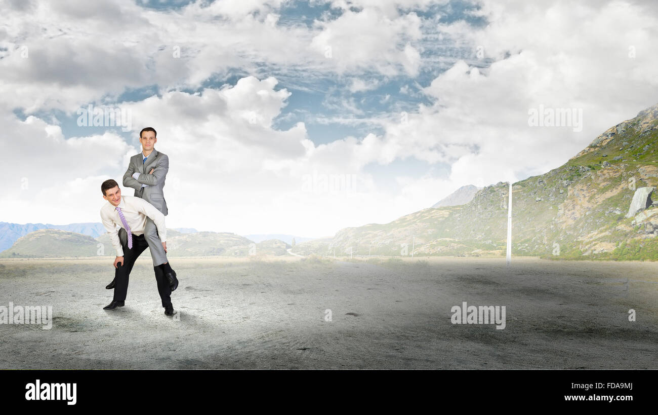 Businessman riding on back of his colleague Stock Photo - Alamy