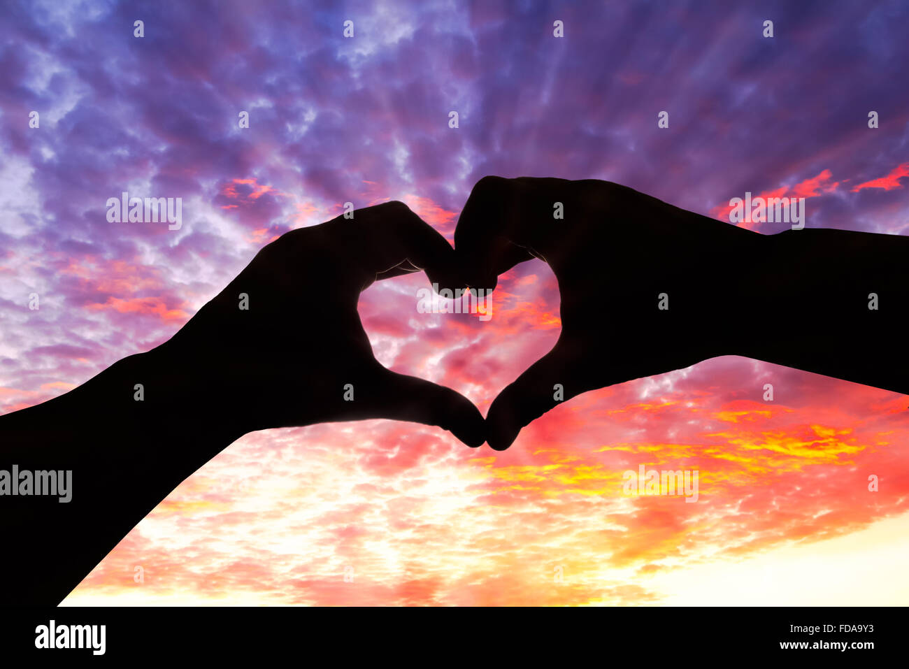 Silhouette hand in heart shape and beautiful sky Stock Photo - Alamy