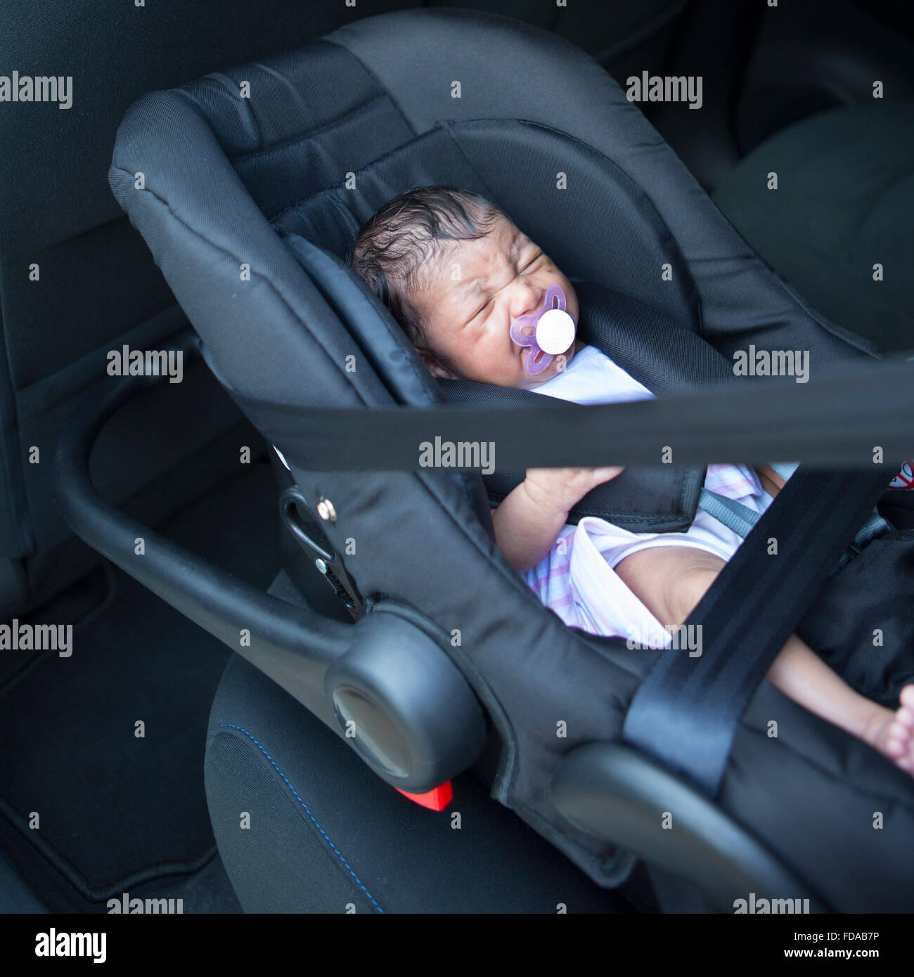 A newborn baby girl in a car seat. Stock Photo