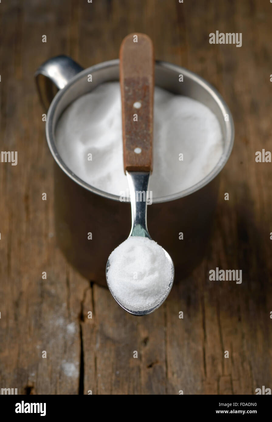 Spoonful of sodium bicarbonate on old wood table Stock Photo