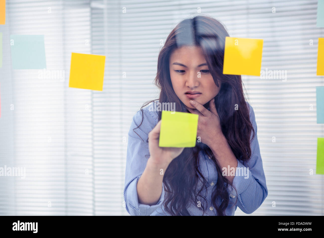 Asian businesswoman using sticky notes on wall Stock Photo - Alamy
