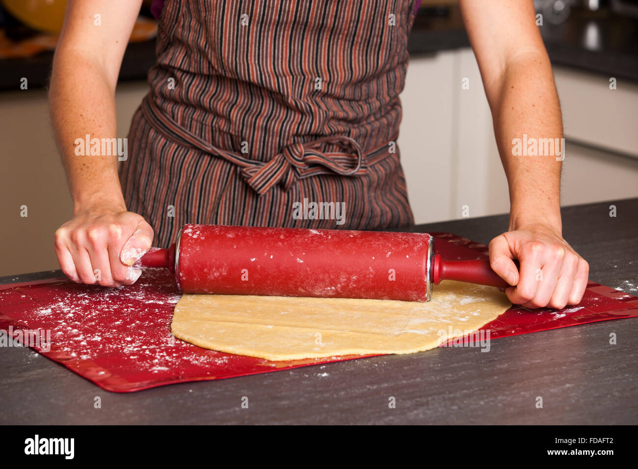 Woman rolling cookie dough with rolling pin Stock Photo