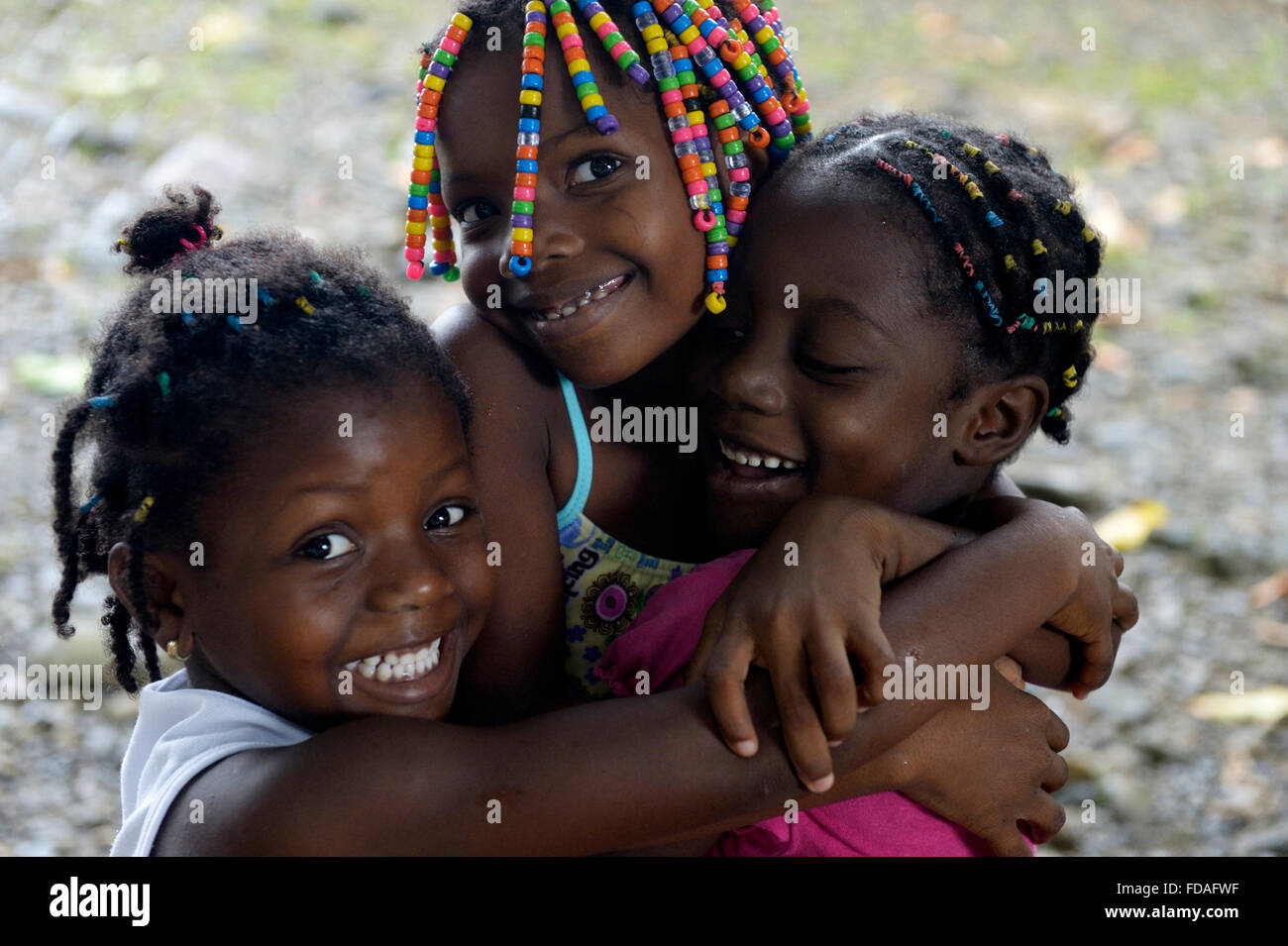 Three girls hugging each other, afro-columbian village of Playa Bonita on the river Rio Andagueda, Chocó Department, Colombia Stock Photo