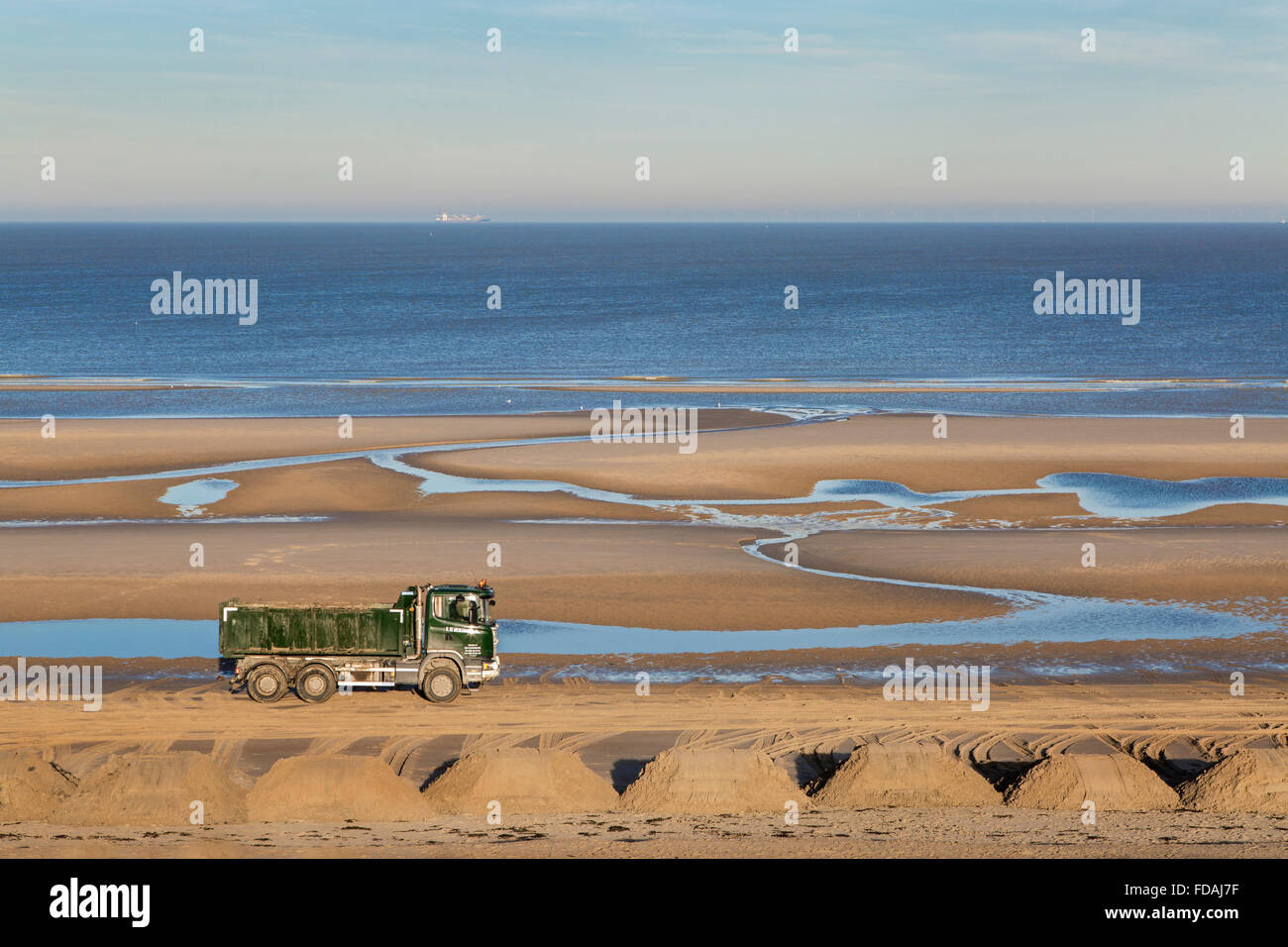 Truck at work to raise the beach along the North Sea coast at Blankenberge, Belgium Stock Photo