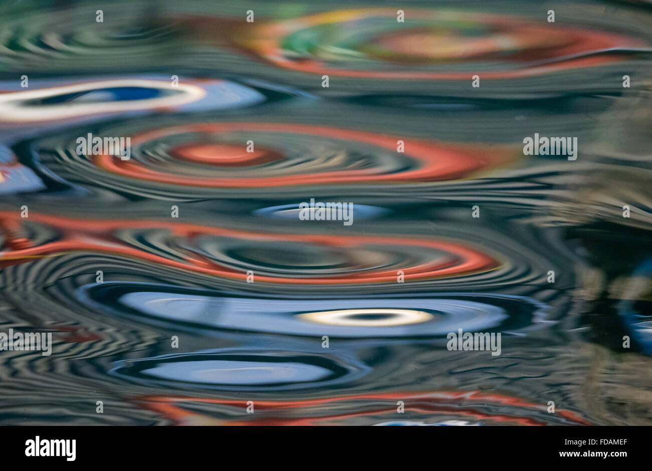 multiple coloured colored patterns reflecting off a calm Mediterranean water surface Stock Photo