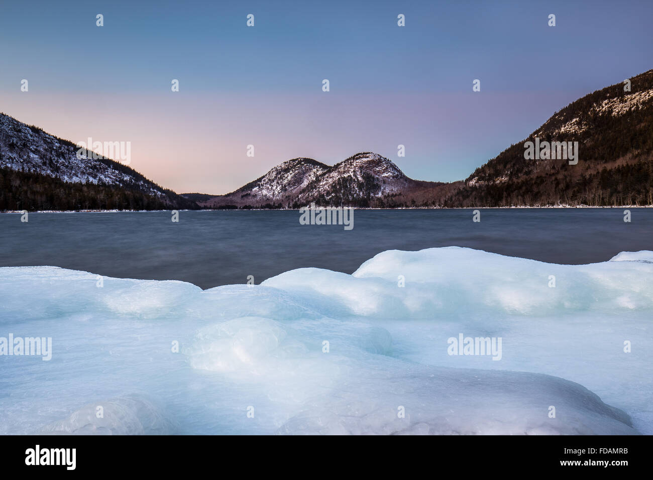 The Bubbles, snow capped and seen from the icy shore of Jordan Pond in Acadia National Park, Mount Desert Island, Maine. Stock Photo