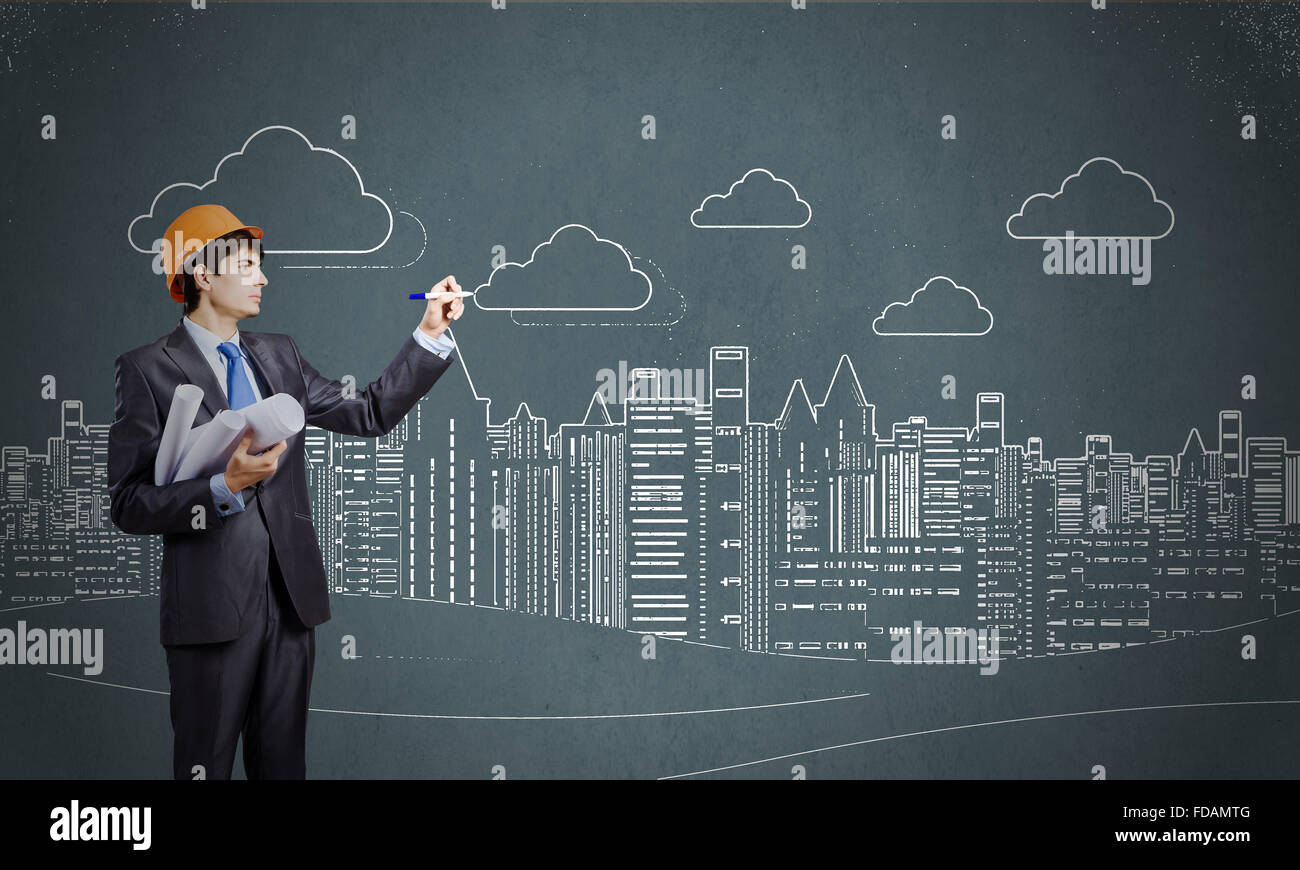 Young man engineer in helmet drawing construction project Stock Photo ...