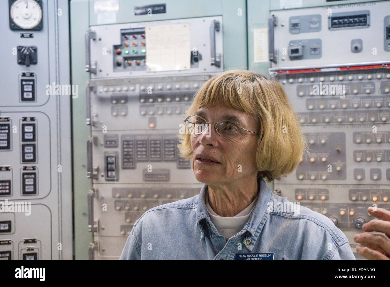 dedicated volunteer docent former Air Force member explains launch procedure to tour group in underground launch control center Stock Photo