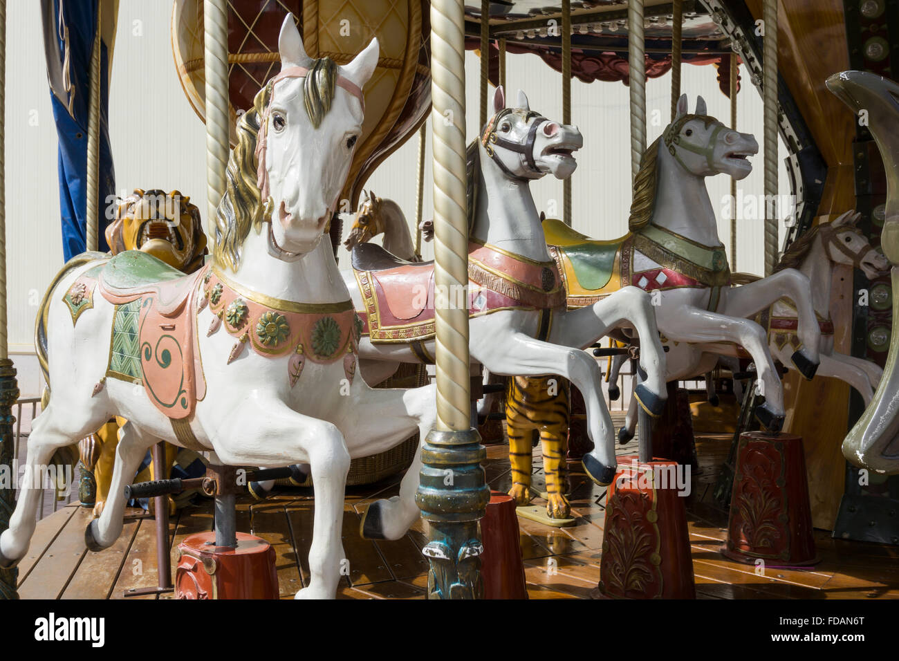Selective focus on three white carousel horses Stock Photo