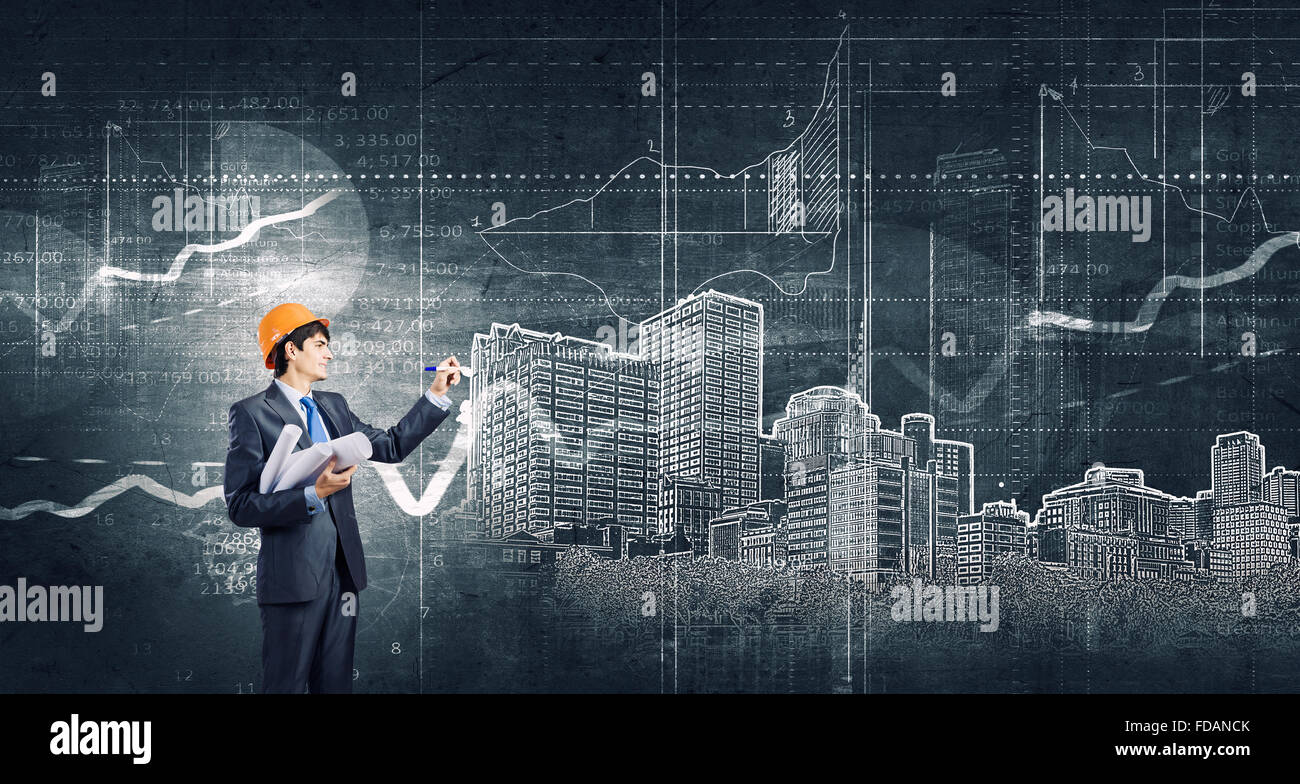 Young man engineer in helmet drawing construction project Stock Photo ...