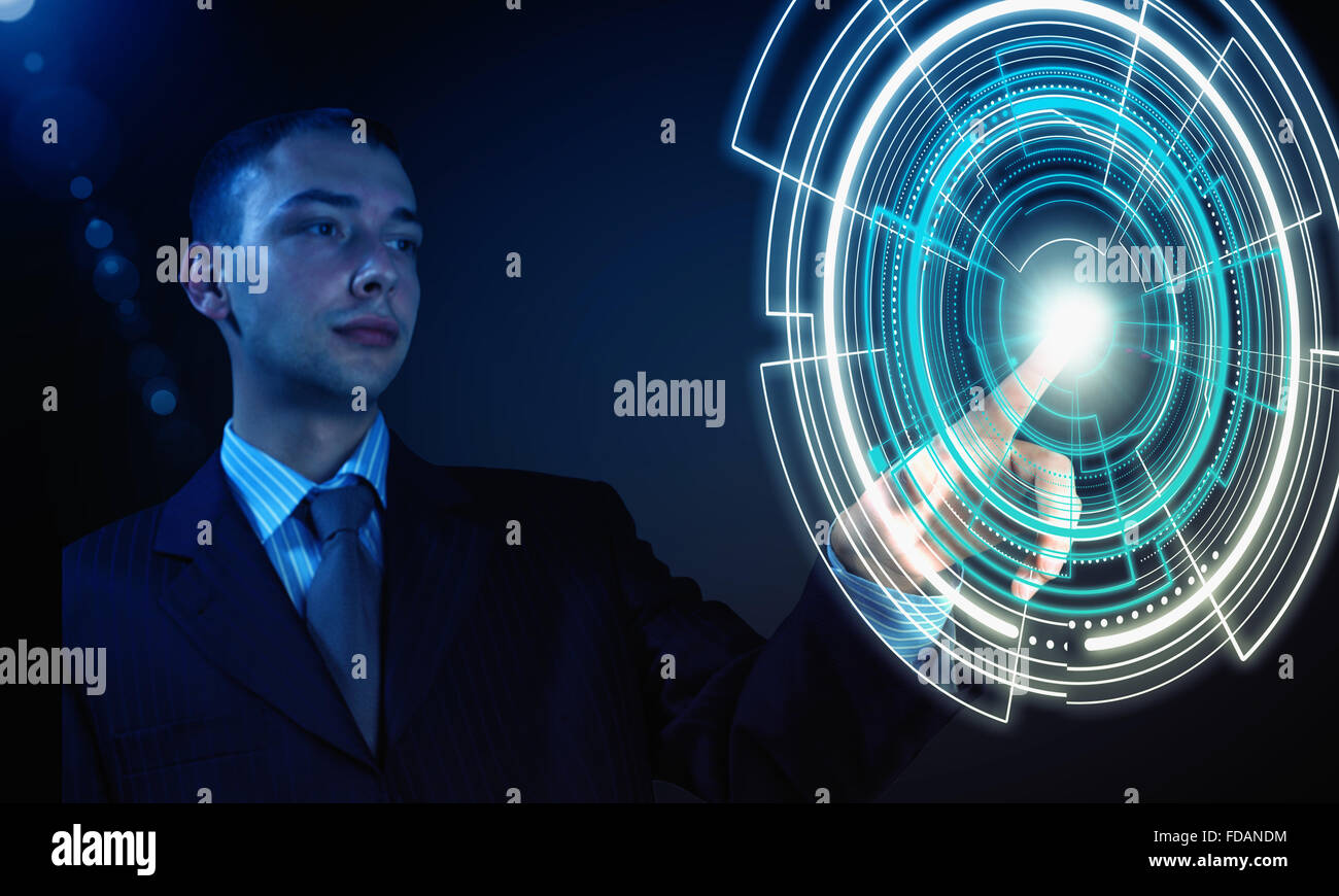 Young businessman pressing high tech circle icon on media screen Stock Photo