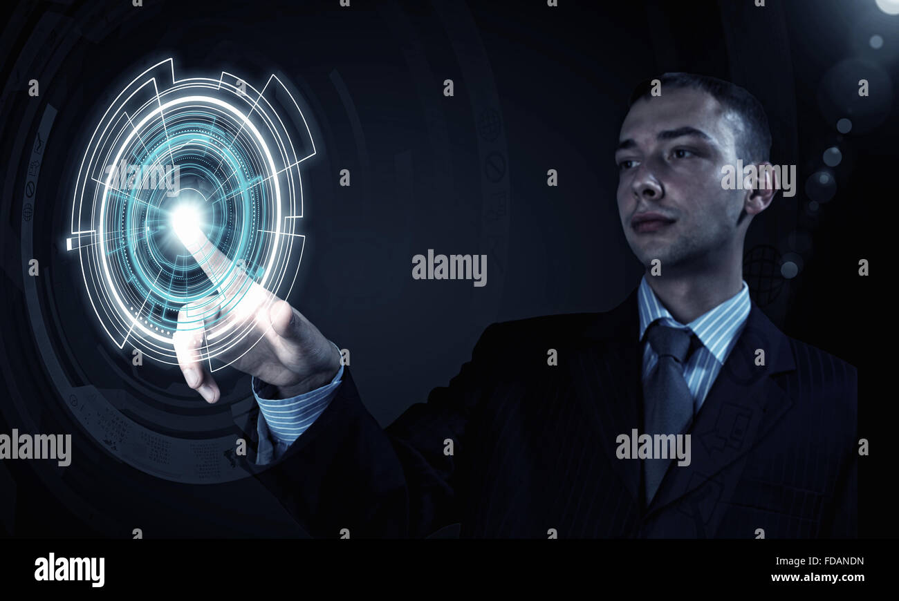 Young businessman pressing high tech circle icon on media screen Stock Photo