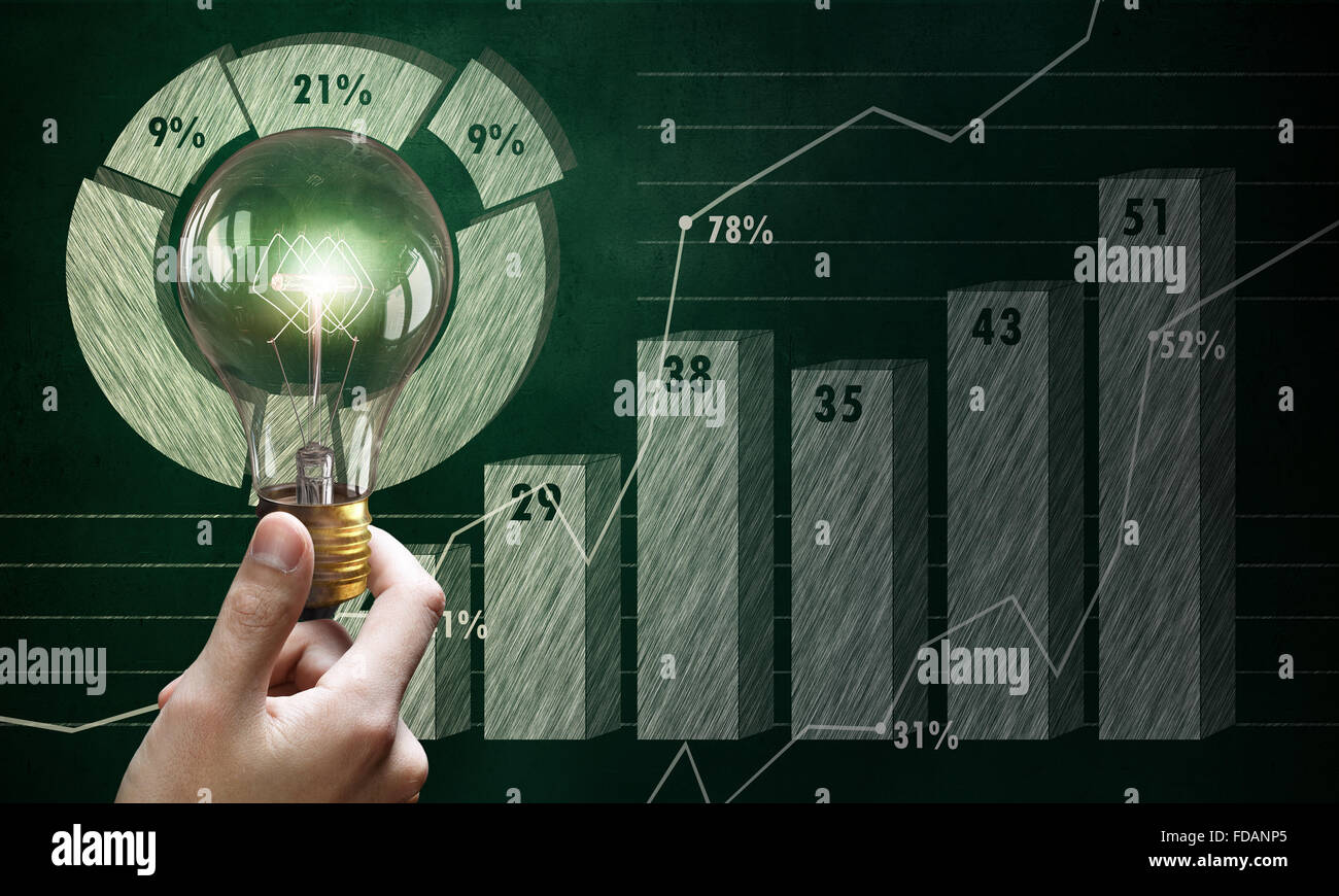 Male hand holding light bulb on background of diagrams and graphs Stock ...