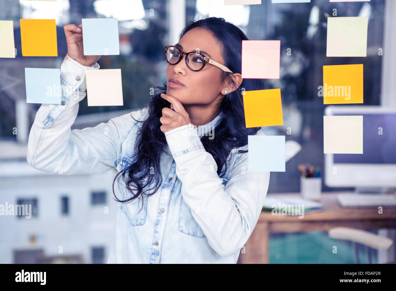 Asian woman looking at sticky notes Stock Photo - Alamy
