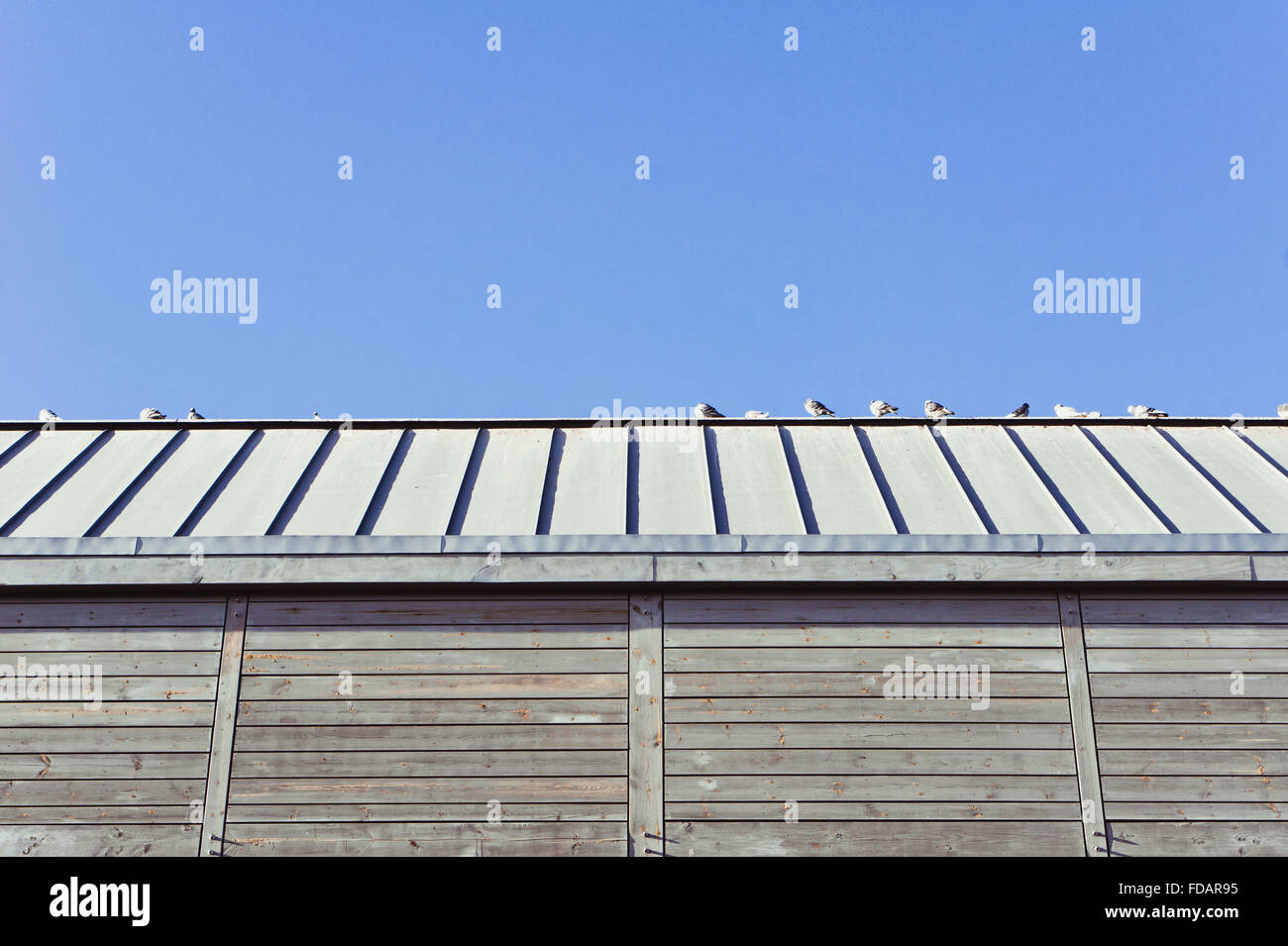 Part of a modern wooden building against a blue sky Stock Photo - Alamy
