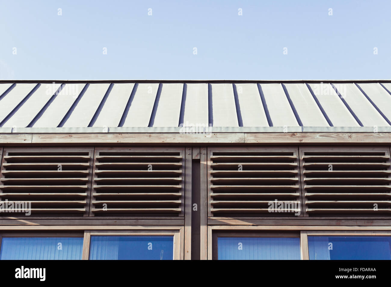 Part of a modern wooden building against a blue sky Stock Photo - Alamy