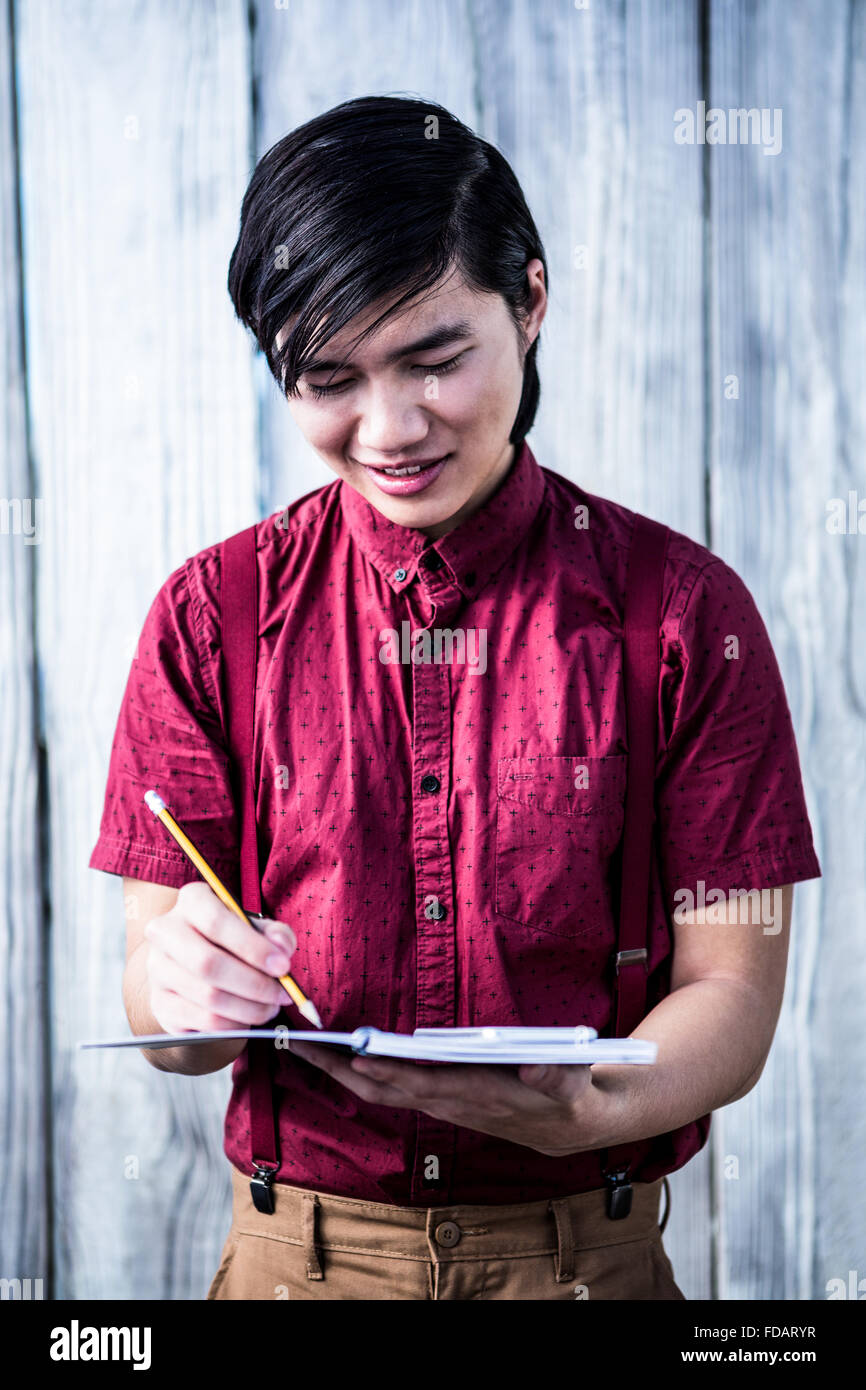 Smiling hipster takes notes with his smartphone Stock Photo - Alamy