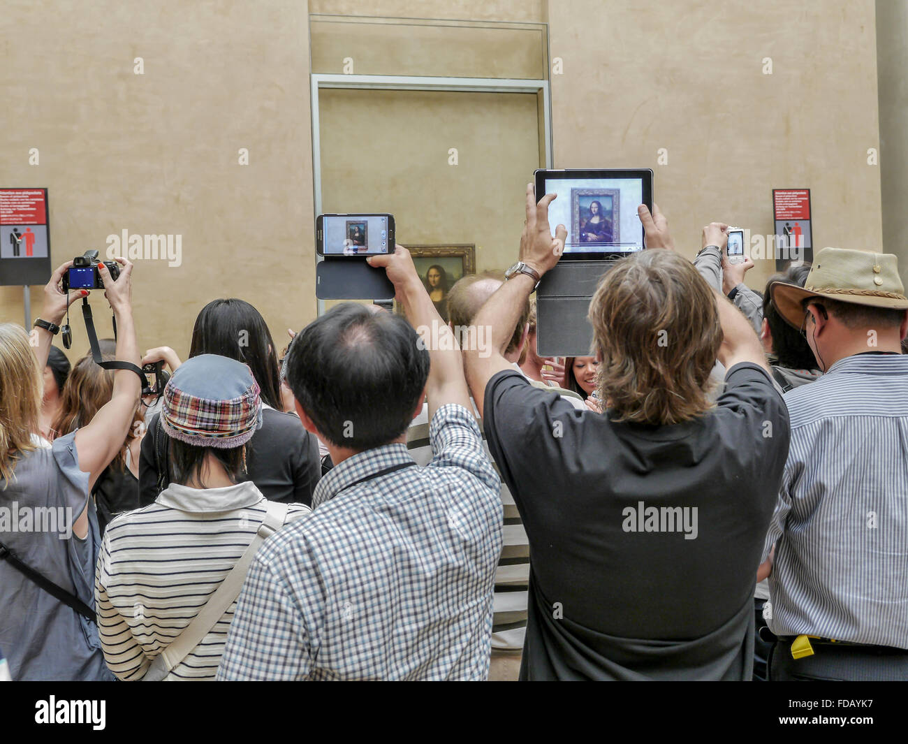 PARIS, FRANCE - AUGUST 28 2013: - A crowd of visitors taking pictures of Leonardo Da Vinci's famous portrait of 'Mona Lisa' Stock Photo
