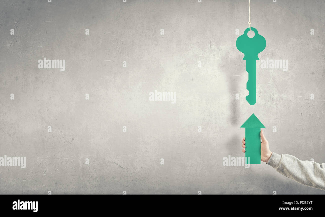 Hand of businessman holding green arrow and pointing at key Stock Photo ...