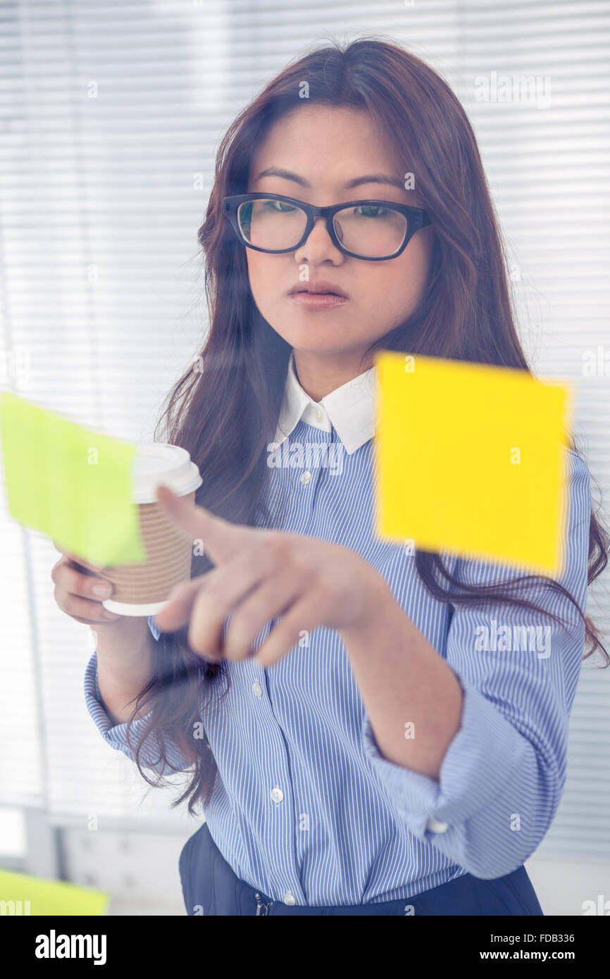 Asian businesswoman using sticky notes on wall Stock Photo - Alamy