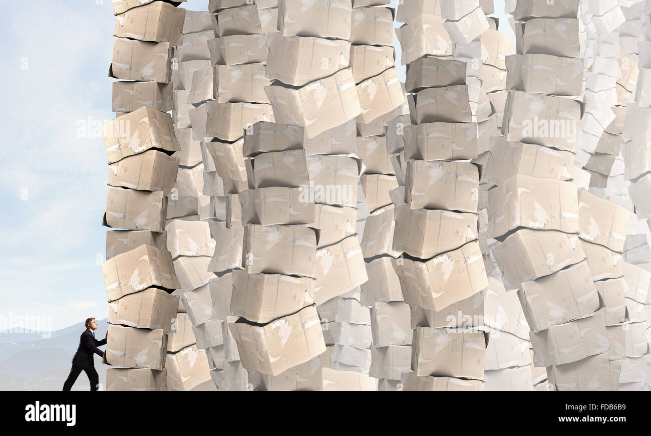 Businessman trying to move big stack of carton boxes Stock Photo - Alamy