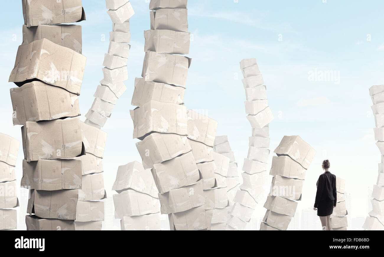Rear view of businesswoman looking at big stack of carton boxes Stock ...