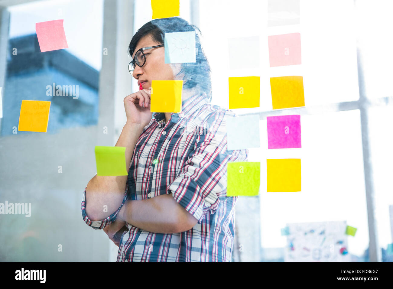 Thoughtful creative businessman looking at sticky notes Stock Photo - Alamy
