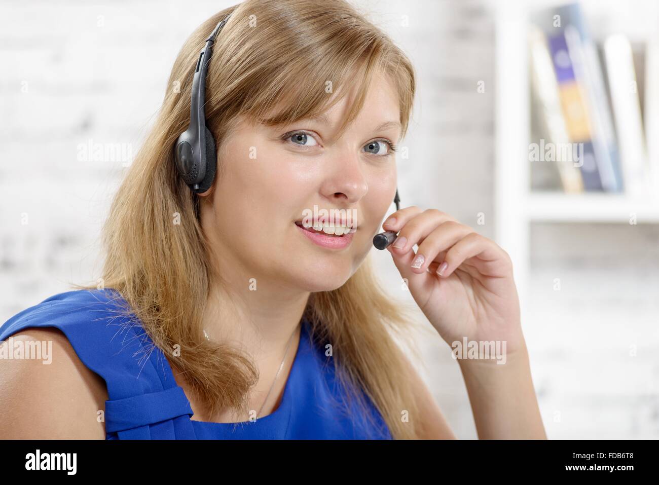 A portrait of smiling cheerful support phone operator in headset stock