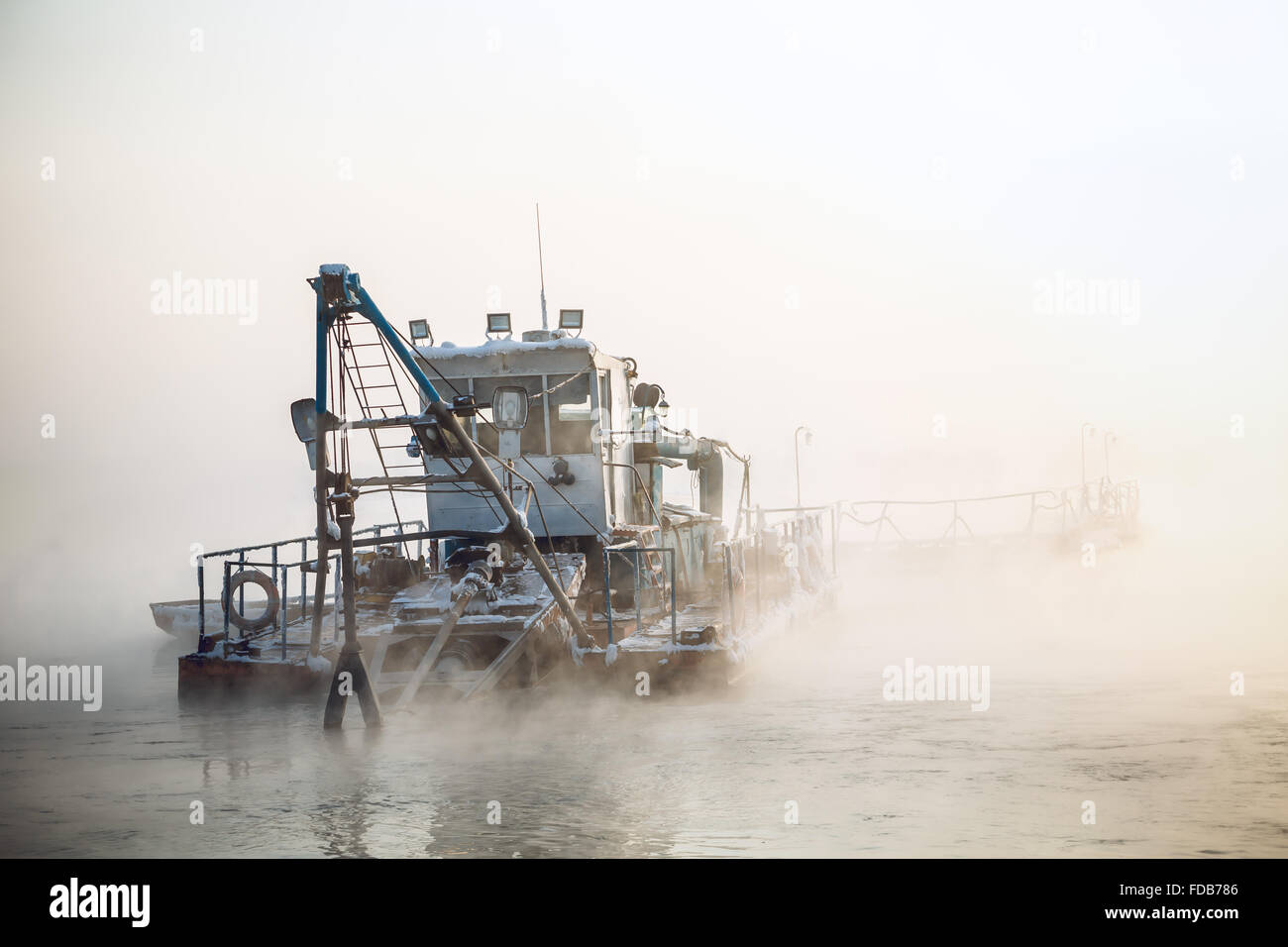 dredge boat in the fog Stock Photo