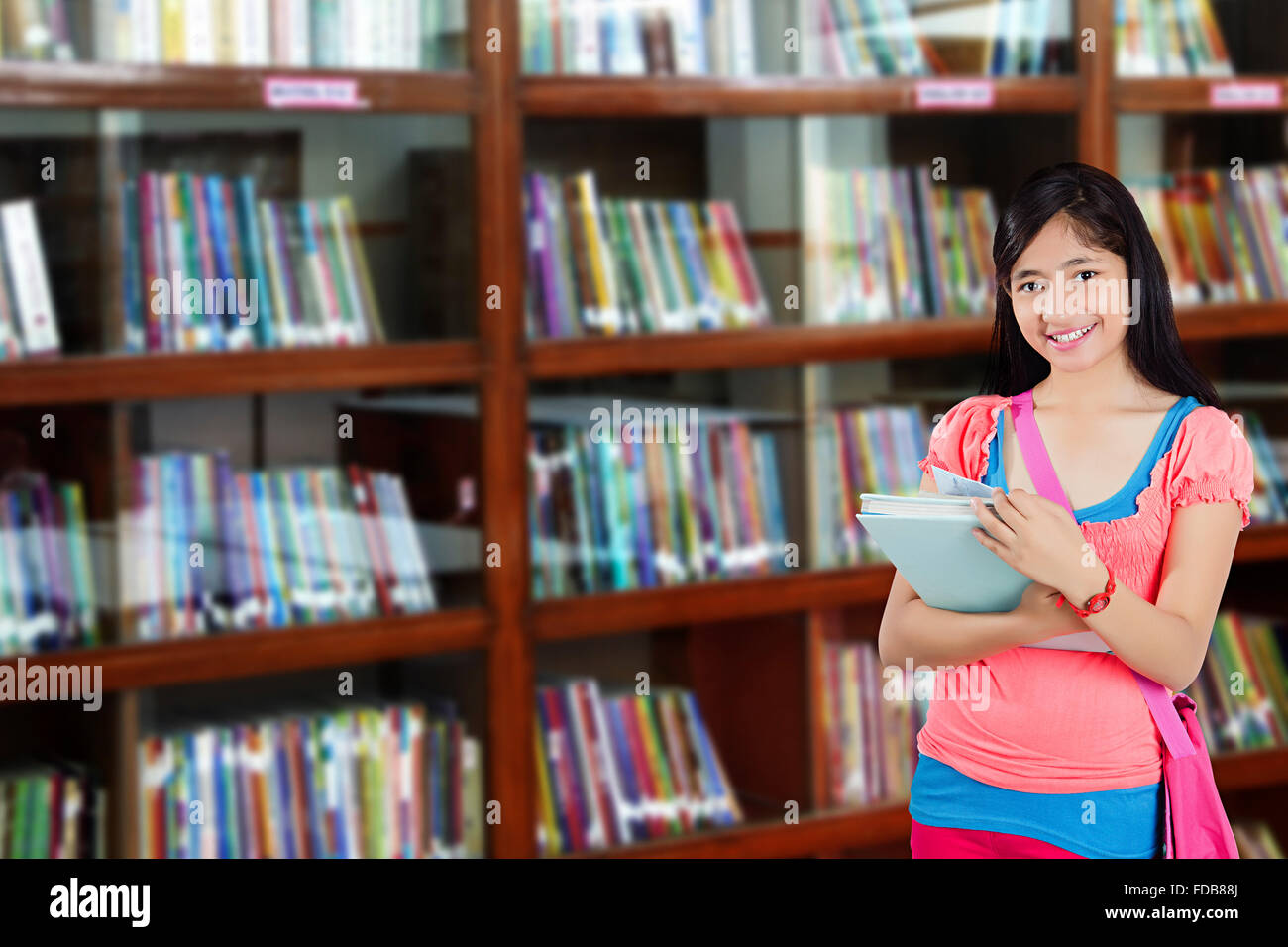 1 Teenager Girl College Student Standing Library Holding Book Stock Photo