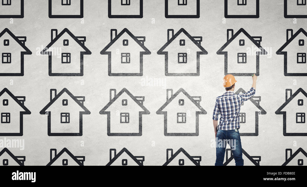 Rear view of engineer drawing project of house on wall Stock Photo - Alamy