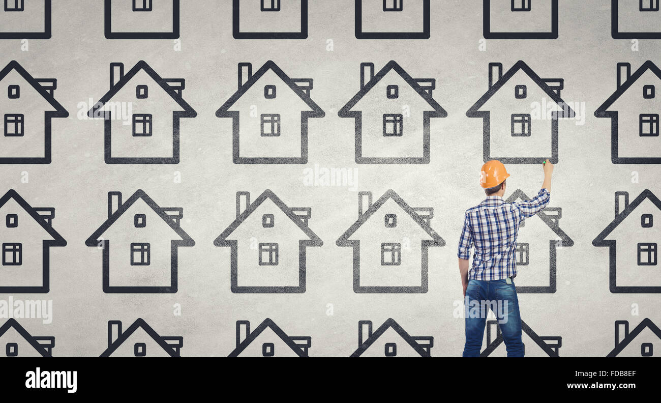 Rear view of engineer drawing project of house on wall Stock Photo - Alamy