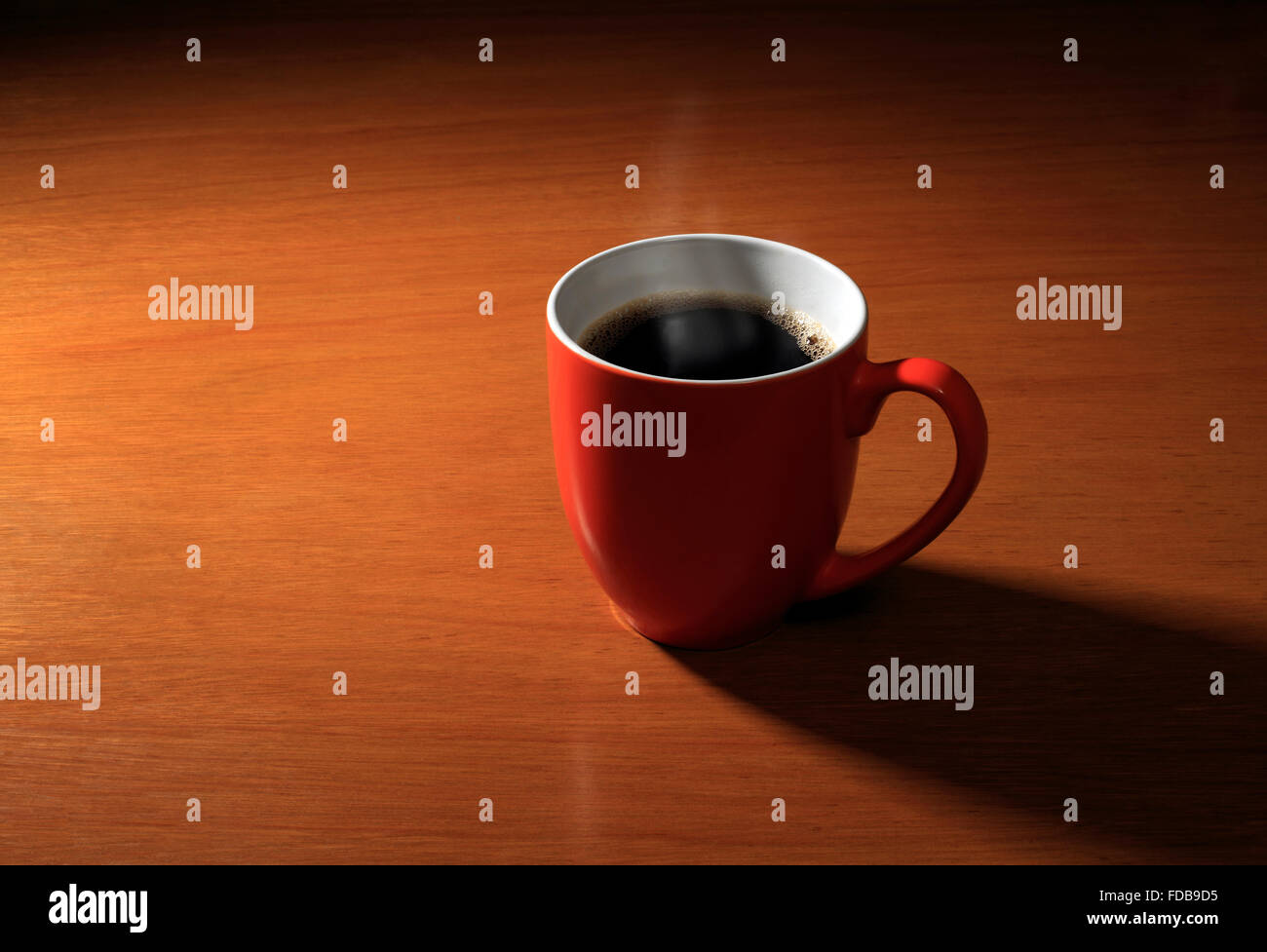Studio shot of an orange mug of hot coffee Stock Photo