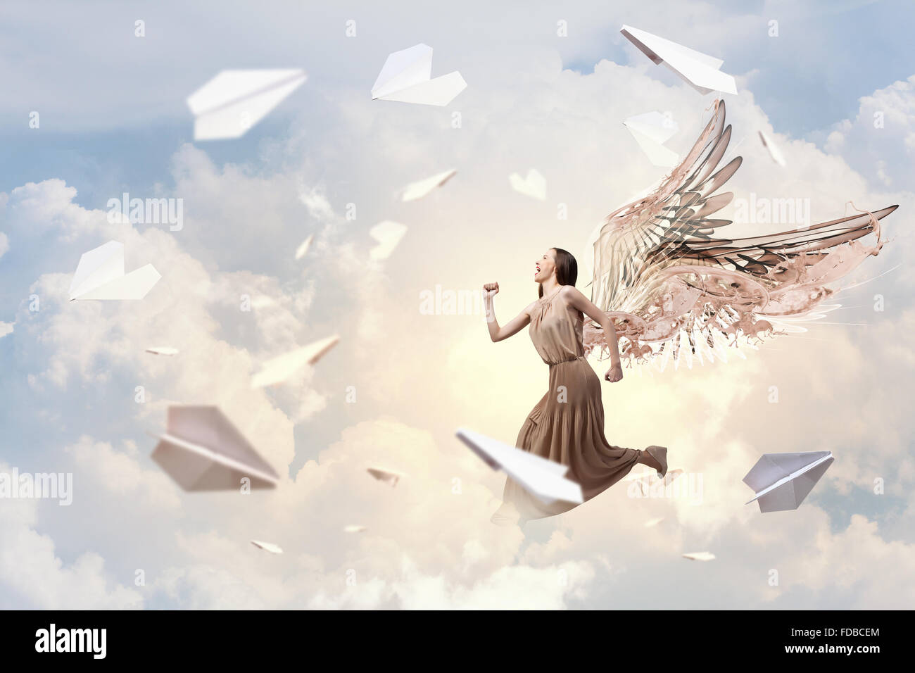 Attractive woman running with angel wings behind back Stock Photo - Alamy