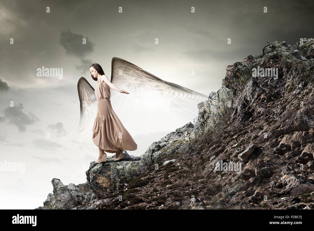 Attractive woman running with angel wings behind back Stock Photo - Alamy