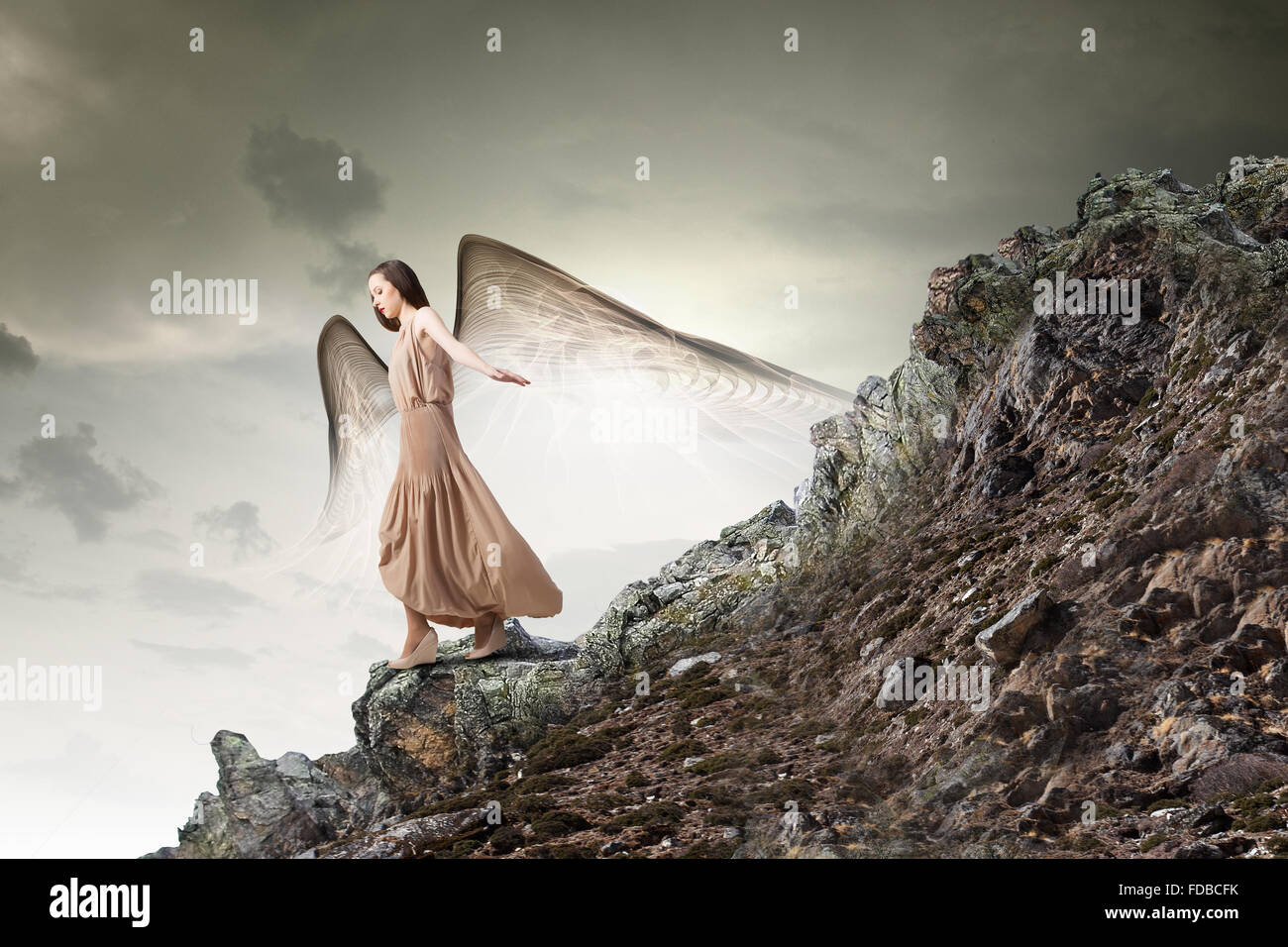Attractive woman running with angel wings behind back Stock Photo - Alamy