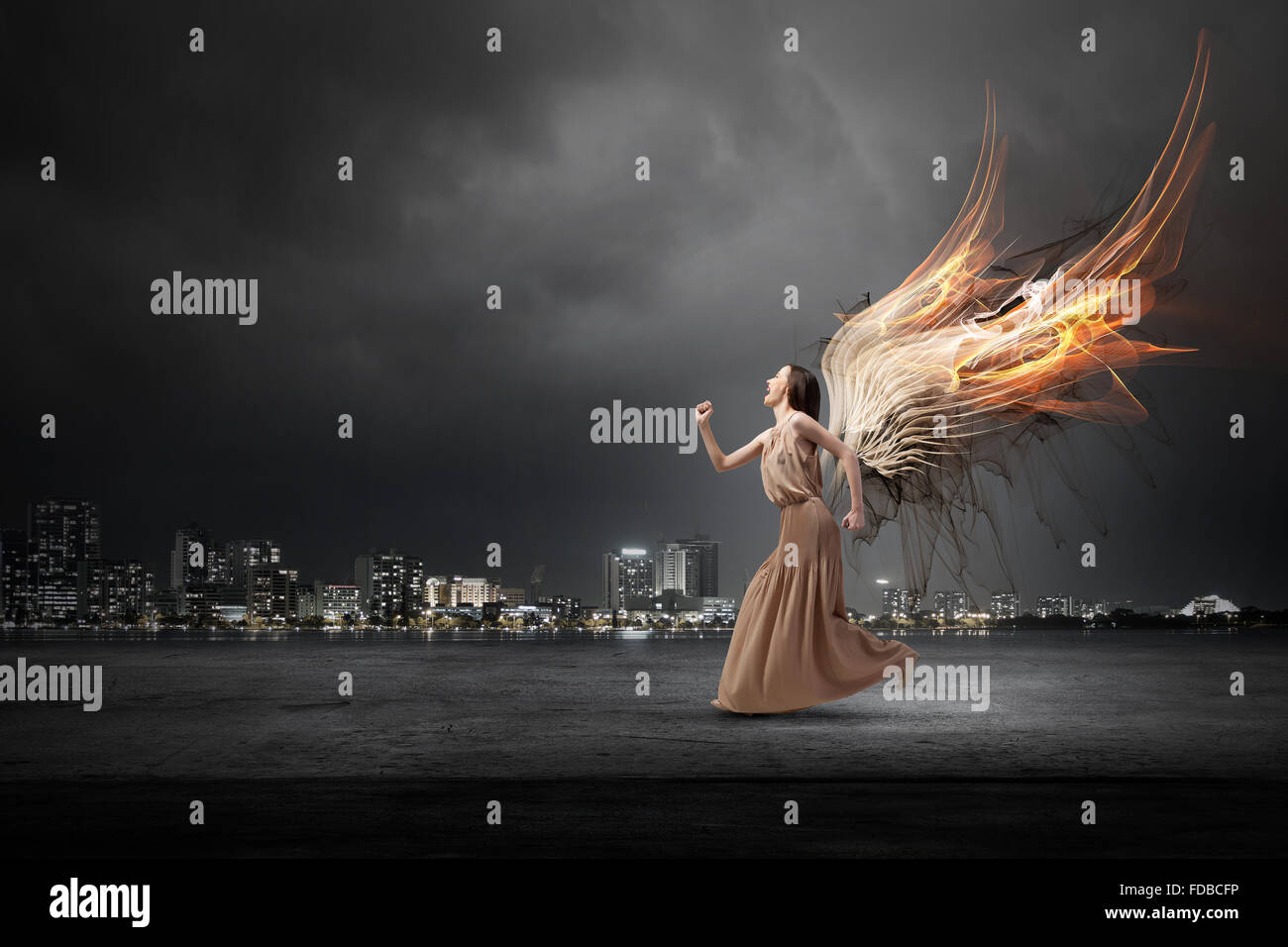 Attractive woman running with angel wings behind back Stock Photo - Alamy