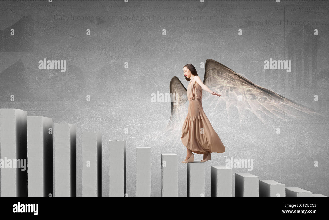Attractive woman running with angel wings behind back Stock Photo - Alamy