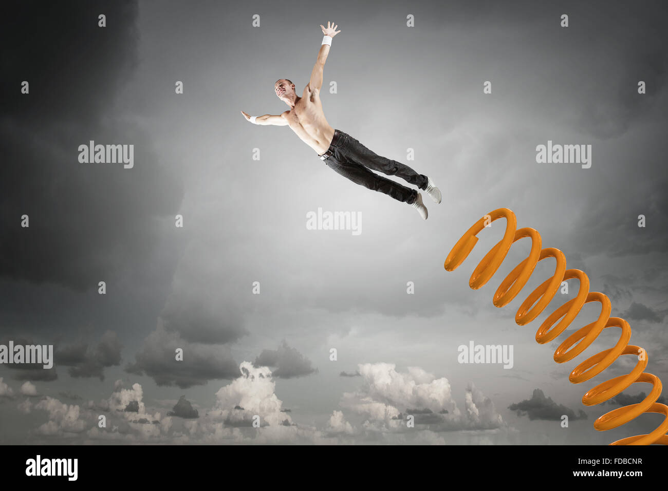 Young man jumping on spring and flying in air Stock Photo - Alamy